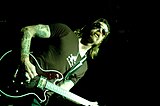 Photo of Jesse Hughes playing a guitar