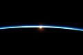 Von der ISS in Ebene des Terminators aus gesehen erleuchtet gestreutes Licht die Erdatmosphäre[9]