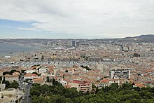 Elevated view of the Old Port of Marseille with red tile-roofed surrounding a quay of yachts