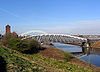 A bridge with a curving arch crossing a canal, with the hydraulic tower on the left