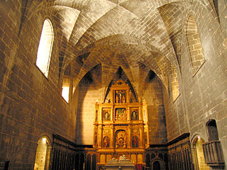 Chapel of the Kings, with the Renaissance altarpiece in the center, the marble tomb in front, and the arches to the right and left