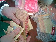 Joss paper of the silver variety being folded for burning