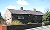 A long, low two-storey house with mullioned windows