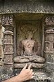 An idol of 23rd Tirthankara Parshvanatha depicting Śvetāmbara iconography (with a piece of cloth carved below the folded legs) on the outer walls of a Jain temple on Pavagadh Hill