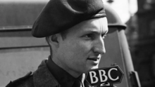 Headshot of a man in military-style uniform in front of a BBC microphone