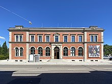 Das Backsteingebäude der MEWO Kunsthalle steht parallel zur Bahnhofstraße. Die Ecken des Gebäudes und die Umrandungen der Eingangstür und der Fenster sind mit Sandsteinblöcken markiert. Im leicht erhöhten Erdgeschoß – weshalb eine 4-stufige Treppe zum Eingang notwendig ist – schließen die mittige Eingangstür und die jeweils fünf Fenster des symmetrischen Gebäudes mit Rundbögen ab. In der oberen Etage bleiben die Fenster rechteckig, nur das mittlere Fenster (über der Eingangstür) wird von einem dreieckigen Giebelelement bekrönt. Rechts am Gebäude ist ein Werbebanner für eine Ausstellung des Künstlerduos Prinz Gholam von 2020 zu sehen.