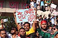 A protester holding a sign reading ১৮ কোটি গুলি আছে তো? ("Have 180 million bullets [for 180 million people]?")