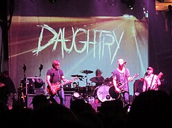 The band Daughtry playing on stage in front of a backdrop displaying its name