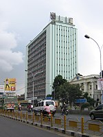 a multi storeyed building with road barricade in the foreground