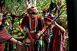 A local lets tourists try on their traditional attire