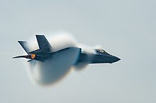 jet plane in sky surrounded by small clouds