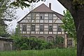 Wohnhaus (Umgebinde), ehemals Faktorei, mit Einfriedung, Garten und Toreinfahrt-Anbau