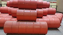 Picture of a reddish sculpture made of oil drums.