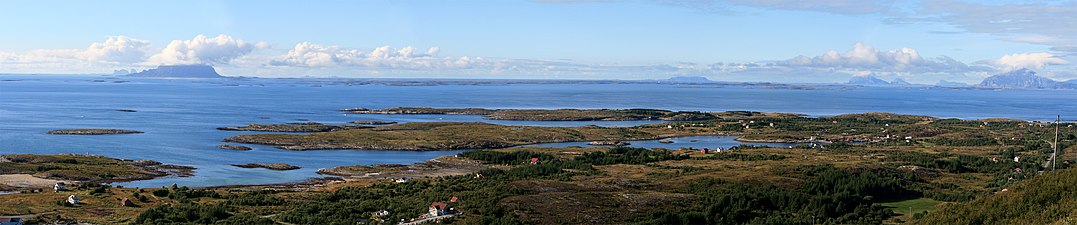 View of the strandflat at Helgeland from the mountain Dønnesfjellet in Dønna. A number of rauks can be seen, from left: Træna, Lovunda, Selvær, Nesøya, Hestmona, Rødøyløva, and Lurøyfjellet, all landmarks on the Norwegian coast.