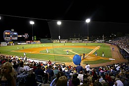 A green baseball field illuminated for a night game