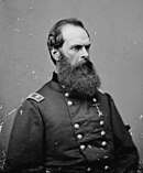 Black and white photo of a man with a thick beard and a receding hairline. He wears a dark military uniform with the two stars of a major general on the shoulder tabs.