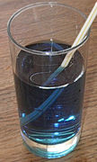 The straw appears to be broken because of the difference between the angle at which light from it strikes the vertical edge of the glass versus the horizontal surface of the water.