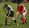 Photo de deux joueurs de shinty en train de se disputer la balle