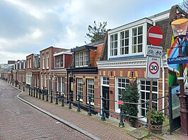 De Slatuinenweg gezien vanaf de Admiraal de Ruijterweg met de helling van polderniveau (links) naar stadsniveau (rechts); maart 2022.