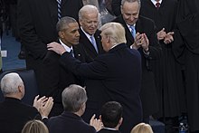 Photo of Trump speaking to Biden and Obama, with Trump's hand on Obama's shoulder