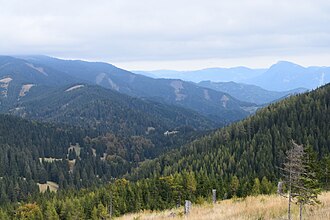 Blick vom Hang südlich oberhalb des Pöllasattels nach Nordosten über das Ende des Groß-Gößgrabens, den Almwirtsattel (Gebäude in der Bildmitte) und durch den Gamsgraben ins Murtal. Der Hochlantsch rechts im Hintergrund liegt bereits östlich des Flusses.