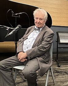 A photo of Mikhail Voskresensky seated in front of a piano.