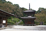 Small wooden two-storied pagoda shaped building with a square base and a round upper floor.