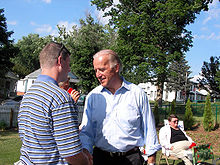 Photo of Biden, casually dressed, talking with a citizen in a garden