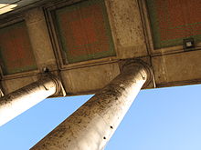 Blick nach schräg oben mit Säulen und Kassetten in der Decke des Portikus