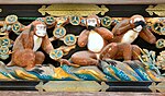 A wooden polychrome carving of three wise monkeys on one of the walls of the temple complex