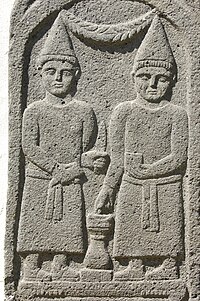 A bas-relief of two men in conic hats and robes