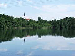 Schloßsee vom Park von Schloss Hartmannsberg, im Hintergrund die Kirche von Stephanskirchen