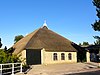 Kop-hals-rompboerderij met voorhuis onder zadeldak met aankapping over de luifel