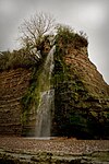 Waterfall cascading down rockface.