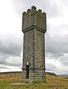 A stone built tower, about 11 meters high, against a cloudy background. The tower has a square base. At the top, there are 3 battlements visible.