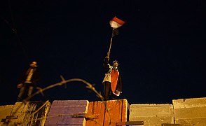 Anti-Mursi-Demonstrant auf der Mauer, die von der Republikanischen Garde errichtet wurde, um Demonstrationen vom Präsidentenpalast fernzuhalten[315]