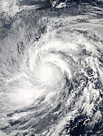 Satellite image of a large tropical cyclone. Though there is no eye, multiple rainbands wrap in an organized fashion about the storm's center.