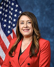 Official House portrait of Rivas smiling in front of the U.S. flag, wearing a black shirt and red jacket with large black buttons.