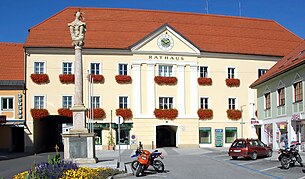 Das Völkermarkter Rathaus, vormals Herzogburg, am Hauptplatz. Im Vordergrund die Dreifaltigkeitssäule