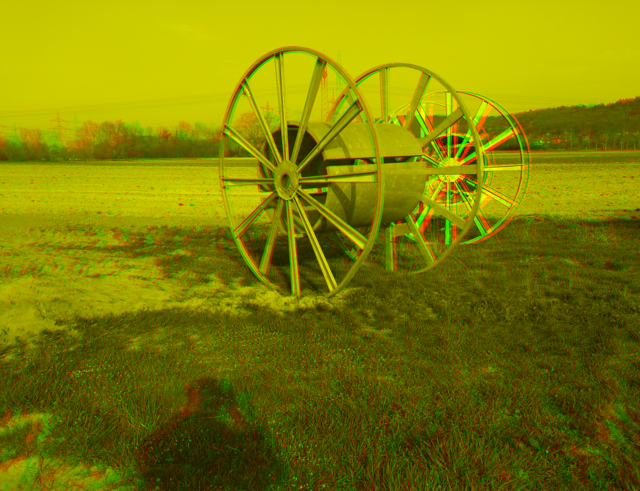 Anaglyph-3D-Bild von zwei Kabelrollen auf einem Feld. Verwenden Sie zur Ansicht den Grünfilter vor dem linken Auge und den Rotfilter vor dem rechten Auge