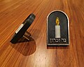 Elektrische Version eines Jahrzeit-Lichtes mit den Worten auf Hebräisch „Kerze [נר] der Erinnerung [זכרון]“.