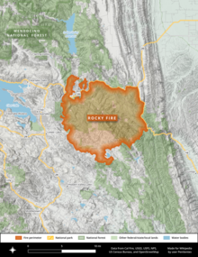 The Rocky Fire footprint is shown in bright orange as an irregular circle, bounded by CA 16 and CA 20 with Clear Lake to the west and Interstate 5 to the east