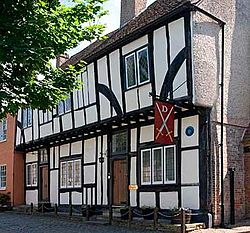 Black and white half-timbered house surrounded by trees