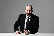 Head and shoulders of a smiling 30ish man with dark hair