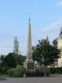 Obelisk mit vergoldeter Spitze. Auf dem Obelisk prangt ein vergoldetes Wappen der Stadt Wien in einem Lorbeerkranz. Auf dem Sockel eine Tafel mit goldener Schrift: „Die Gartenanlagen auf dem Gürtel zwischen Nussdorferstrasse und dem Wienflusse wurden unter Bürgermeister Dr Karl Lueger nach dem Antrage des Stadtrates Karl Schreiner in den Jahren 1898 bis 1960 ausgeführt.“ Name und Titel Luegers sind größer gesetzt als der Rest der Schrift.