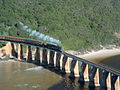 Eine 19D zieht einen Zug über die Brücke über den Kaaimans River