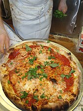 DeMarco adding fresh basil to a Di Fara Pizza