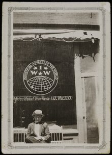 A man sits in front of the windows of the IWW offices in Yakima, Washington.