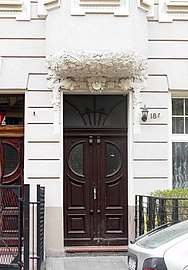 Gate decoration with leaves and the head of a woman