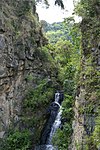 Small waterfall sided by two large rocks.